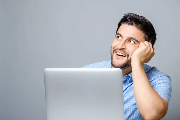 Afbeelding van thinkful man, gekleed in een blauw shirt met laptop compute — Stockfoto