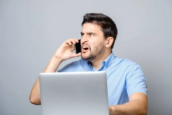 Portret van angry young man schreeuwen op zijn mobiele telefoon — Stockfoto