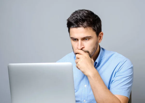 Portrait of serious concentrated man working at laptop — Stock Photo, Image