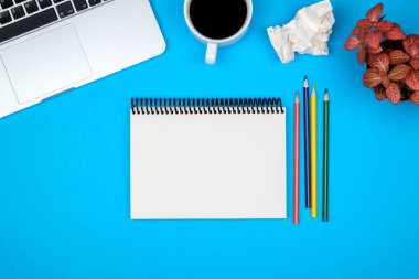 Dizüstü bilgisayar ve boş Not Defteri sayfası en az çalışma masası