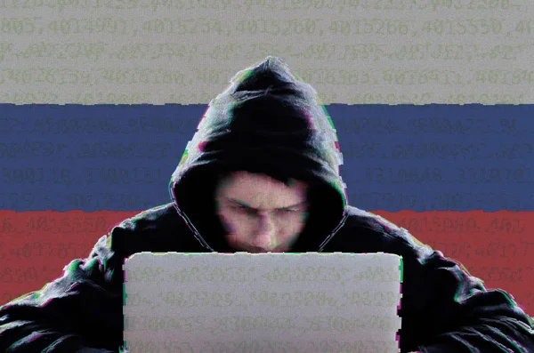黑客在黑暗餐饮与俄罗斯国旗使用笔记本电脑 — 图库照片