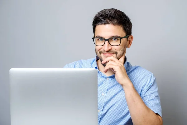 Hombre feliz con ordenador portátil aislado en gris — Foto de Stock