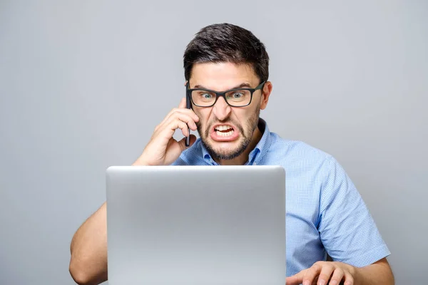 Portret van angry young man schreeuwen op zijn mobiele telefoon — Stockfoto