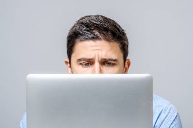 Laptop ile masada oturan dalgın hüzünlü adam