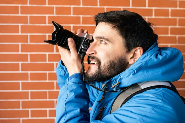 Tourists with camera in the city. Brick wall background — Stock Photo, Image