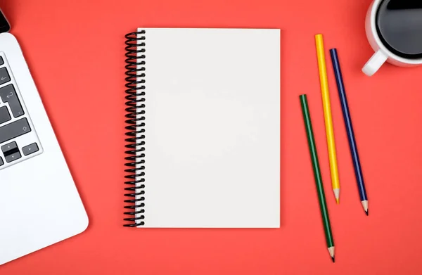 Mesa de escritorio de oficina moderna con computadora portátil y página de cuaderno en blanco — Foto de Stock