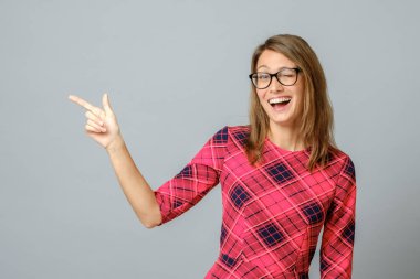 Güzel, neşeli bir kadın. El ve parmaklarıyla el kol hareketi yapıyor.