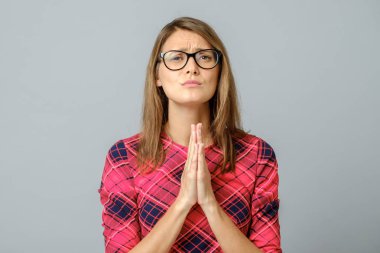 Umut işareti olarak el ele tutuşan bir kadın. Gri torbada izole edilmiş.