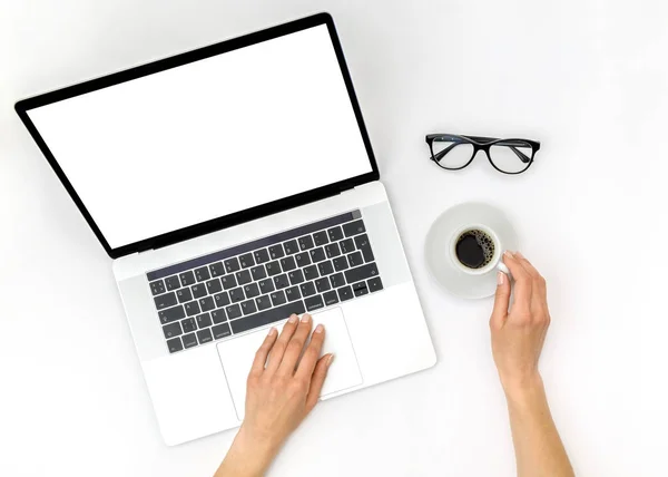 Maqueta del espacio de trabajo de la oficina en casa. Laptop con pantalla en blanco, manos y — Foto de Stock