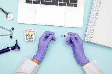 Doktor mavi ofis masasında oturuyor ve çalışıyor.