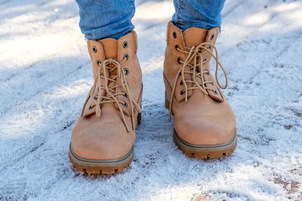 雪の上に立っている茶色のブーツの女性の足 — ストック写真