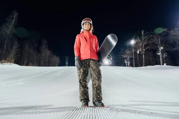 Portrait of female snowboarder at evening slope. Winter sports c — Stock Photo, Image