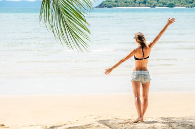 Kaldırılmış elleri olan güzel, esmer bir kızın arka manzarası.