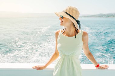 Yaz tatili boyunca teknede gülümseyen genç bir kadın.