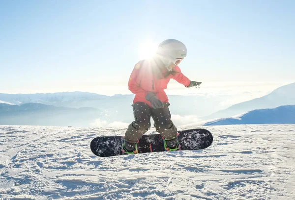 Snowboard 'da güzel genç bir kadın yamaçtan atlıyor. — Stok fotoğraf