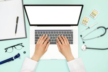 Doktor mavi ofis masasında oturuyor ve çalışıyor.