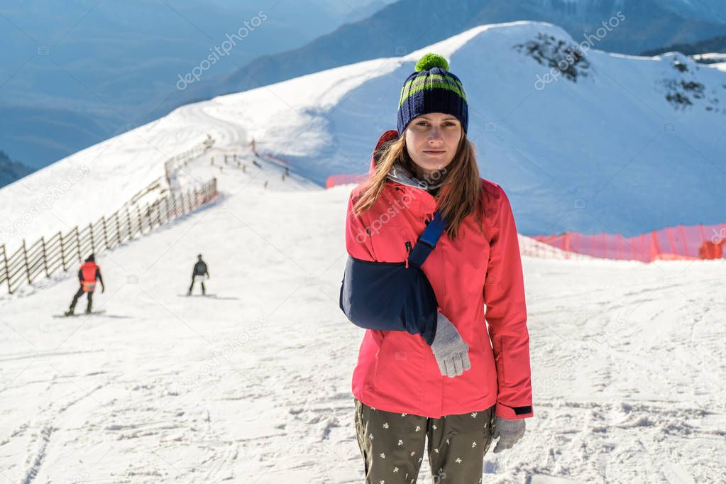 Young woman with her damaged right arm after snowboard riding