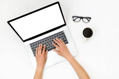 Merkez ofis çalışma alanı modeli. Boş ekranlı dizüstü bilgisayar, beyaz arka planda eller ve aksesuarlar. Düz yatıyordu. Üst görünüm