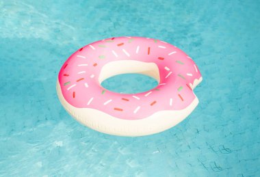 Havuzda yüzen donut şeklinde şişme yüzme halkası.