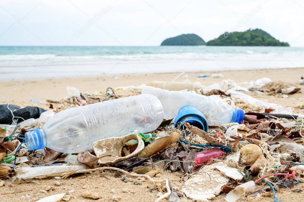 Beach pollution. Plastic bottles and other trash on sea beach. Ecological concept