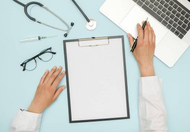 İş yerinde dizüstü bilgisayar ve tıbbi ekipmanlarla çalışan kadın doktor. Sağlık hizmetleri kavramı