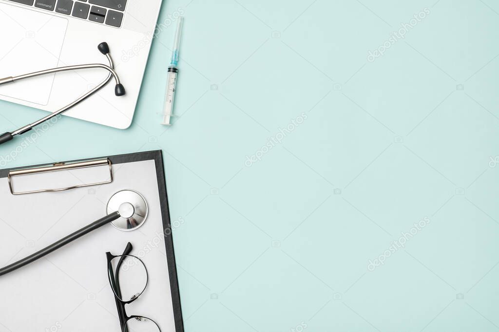 Top view of doctor's desk with laptop. Doctor's work tools, medical equipment. Modern medicine concept