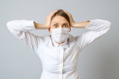 Maskeli doktor gri arka planda izole edilmiş.