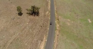 Mavi dağ vadisi sığır çiftlikleri ve uzak yol antenleri ile yaşam tarzını takip eden üstü açık, üstü açık bir araba..