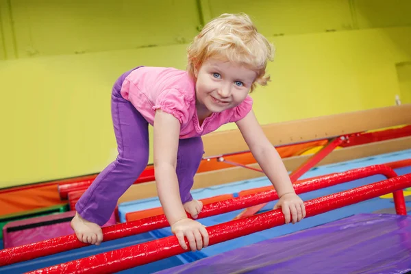 Retrato de niña blanca rubia caucásica feliz sonriente haciendo ejercicios en el gimnasio disfrutando de la clase de deporte — Foto de Stock