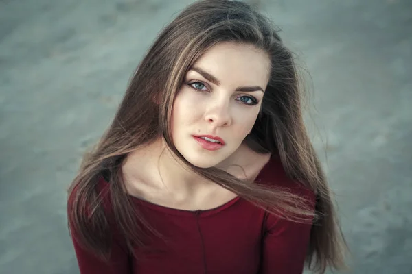 Gros plan portrait de songeur triste solitaire blanc Caucasien jeune belle femme avec les yeux verts et les cheveux longs désordonnés sur la journée venteuse en plein air au coucher du soleil, regardant à la caméra — Photo