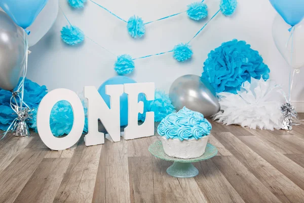 Festliche Hintergrunddekoration für Geburtstagsfeier mit Gourmettorte, Buchstaben "one" und blauen Luftballons im Atelier, Tortenschlagerkonzept im ersten Jahr — Stockfoto