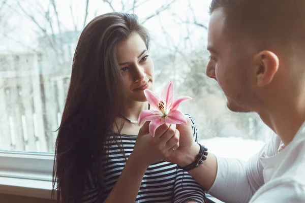 Casal segurando lírio vermelho rosa — Fotografia de Stock