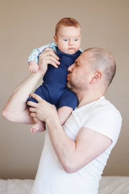  Baba bebeği tutuyor. 
