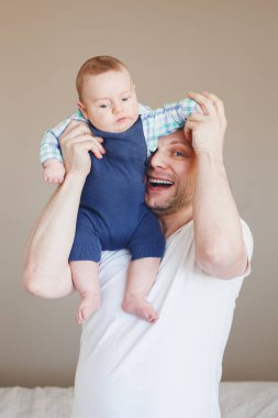  Baba bebeği tutuyor. 