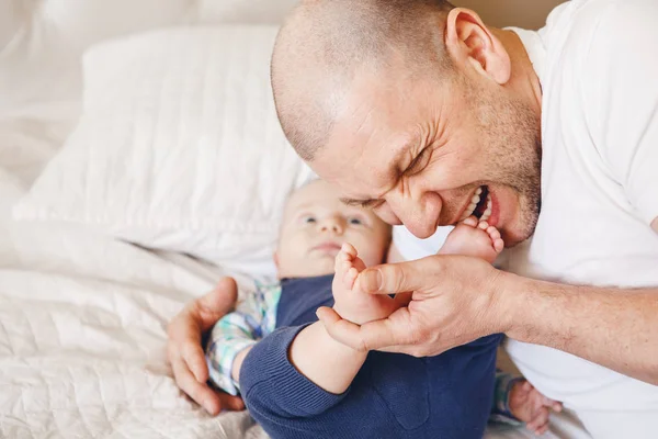 Padre besos dedos de los pies de bebé —  Fotos de Stock