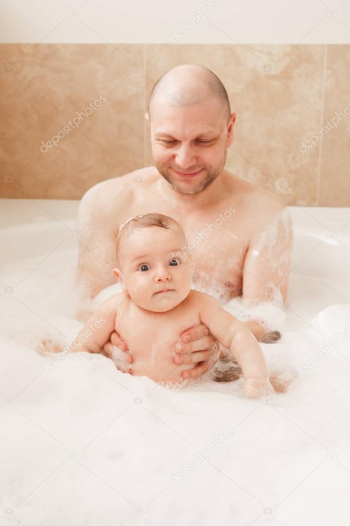 father taking bath together with baby