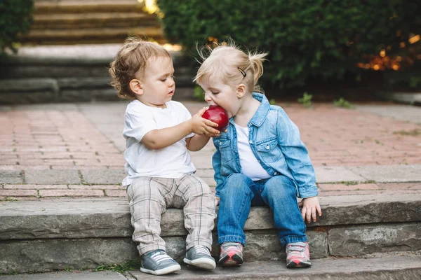 Enfants partageant, mangeant des pommes — Photo