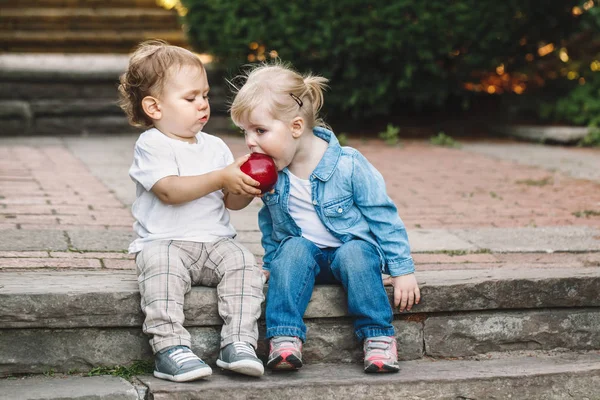 Enfants partageant, mangeant des pommes — Photo