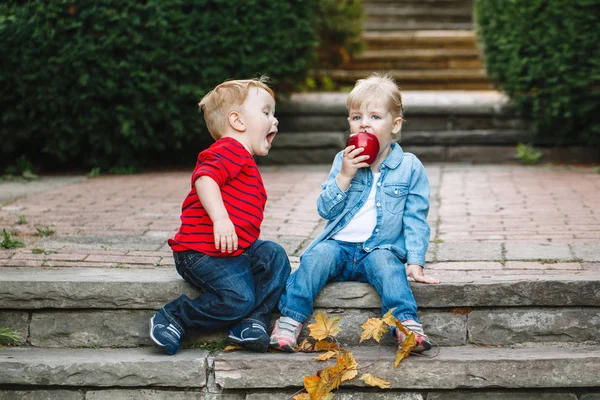 Niños sentados juntos compartiendo manzana —  Fotos de Stock