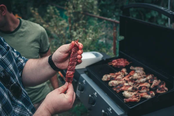 Szaszłyki z surowego mięsa trzymając się za ręce — Zdjęcie stockowe
