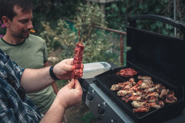 Händer som håller spett med rått kött — Stockfoto