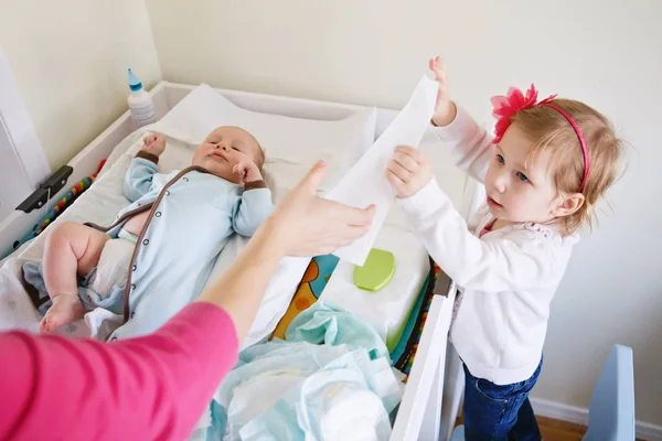 Mãe e filha trocando fralda de bebê — Fotografia de Stock