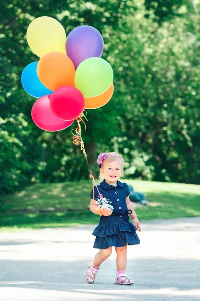 Barn tjej med färgglada ballonger — Stockfoto