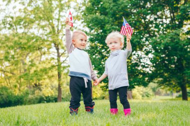 kız ve erkek gülümseyen ve Amerika ve Kanada bayrakları sallayarak