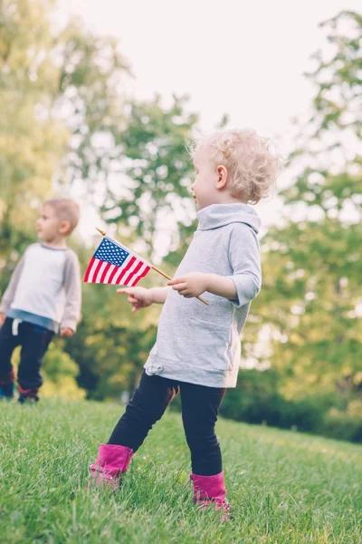 kız ve erkek gülümseyen ve Amerika ve Kanada bayrakları sallayarak