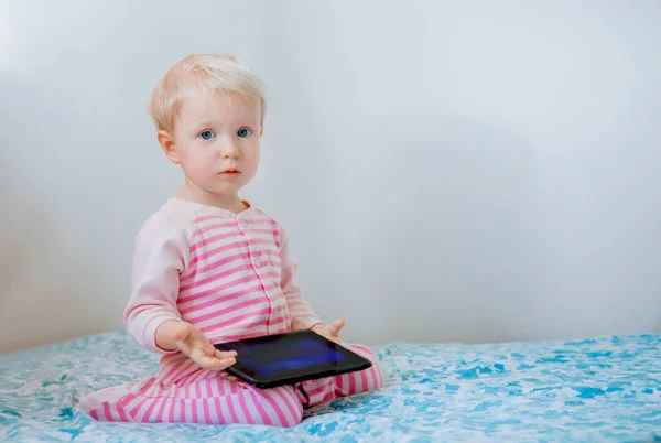 Vaalea vauva tyttö tabletin kanssa — kuvapankkivalokuva