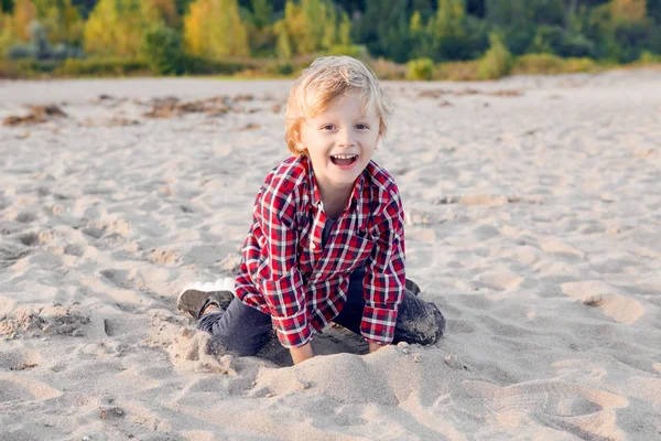 Anak laki-laki pirang duduk bermain dengan pasir — Stok Foto