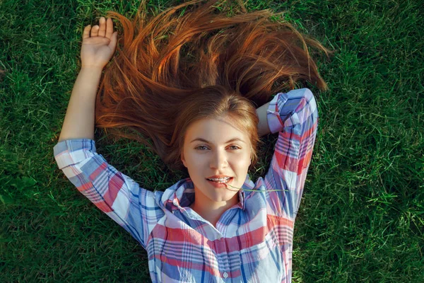 Woman with red hair lying on grass — Stock Photo, Image