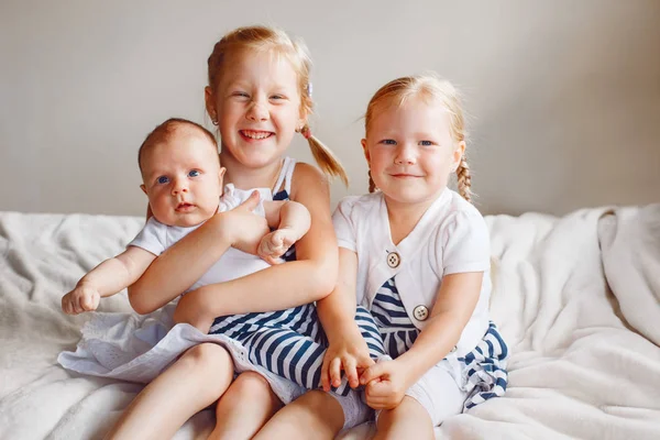 Irmãs segurando bebê pequeno — Fotografia de Stock