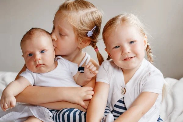 Hermanas sosteniendo pequeño bebé — Foto de Stock